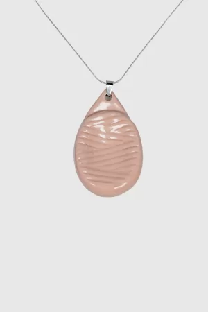 Worry stone: Galet en porcelaine rose pastel avec texture et émail brillant, monté en collier.