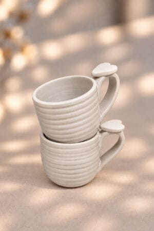 Tasse à café artisanale en grès blanc mat avec un coeur sur l'anse